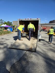 Storm recovery contractor carrying a crate of electrical tools to a trailer